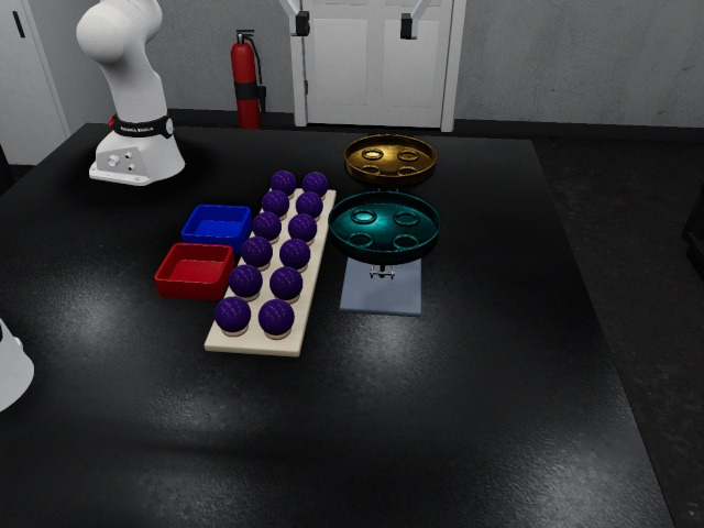 Side camera: the two arms, the rack of purple balls, the trays and the balance on the table